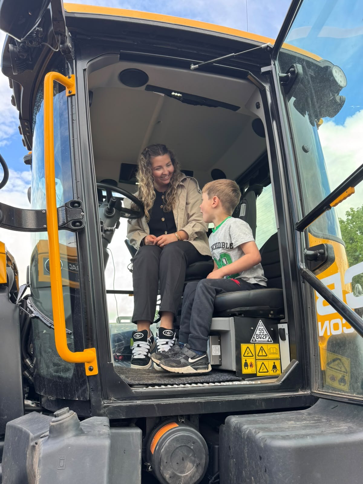 A child exploring a digger cab with a practitioner