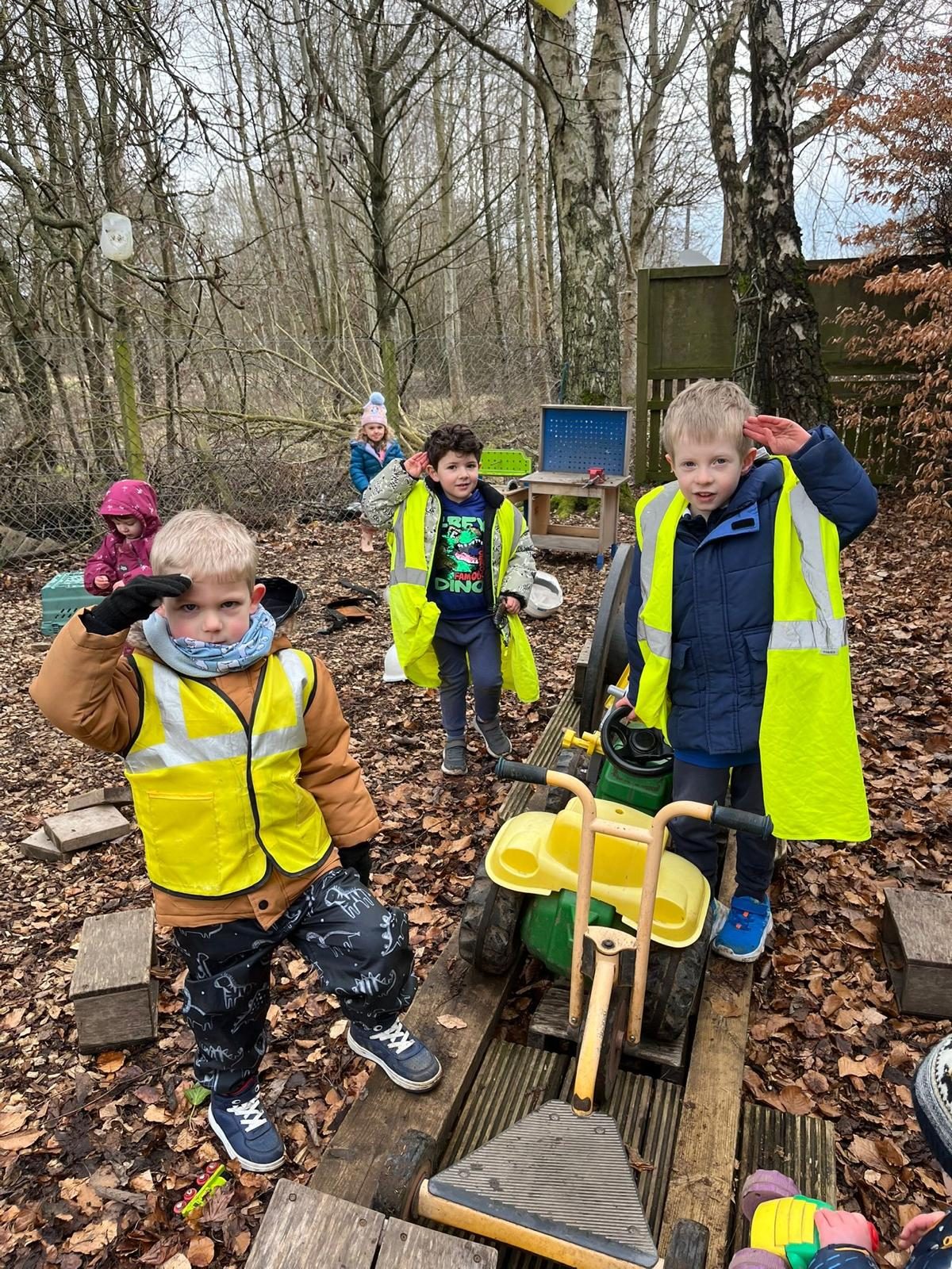 Children in hi-vis jackets exploring the woodland
